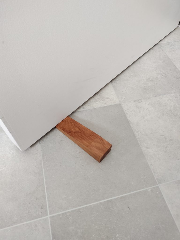 Recycled Rimu Door Stop being used
